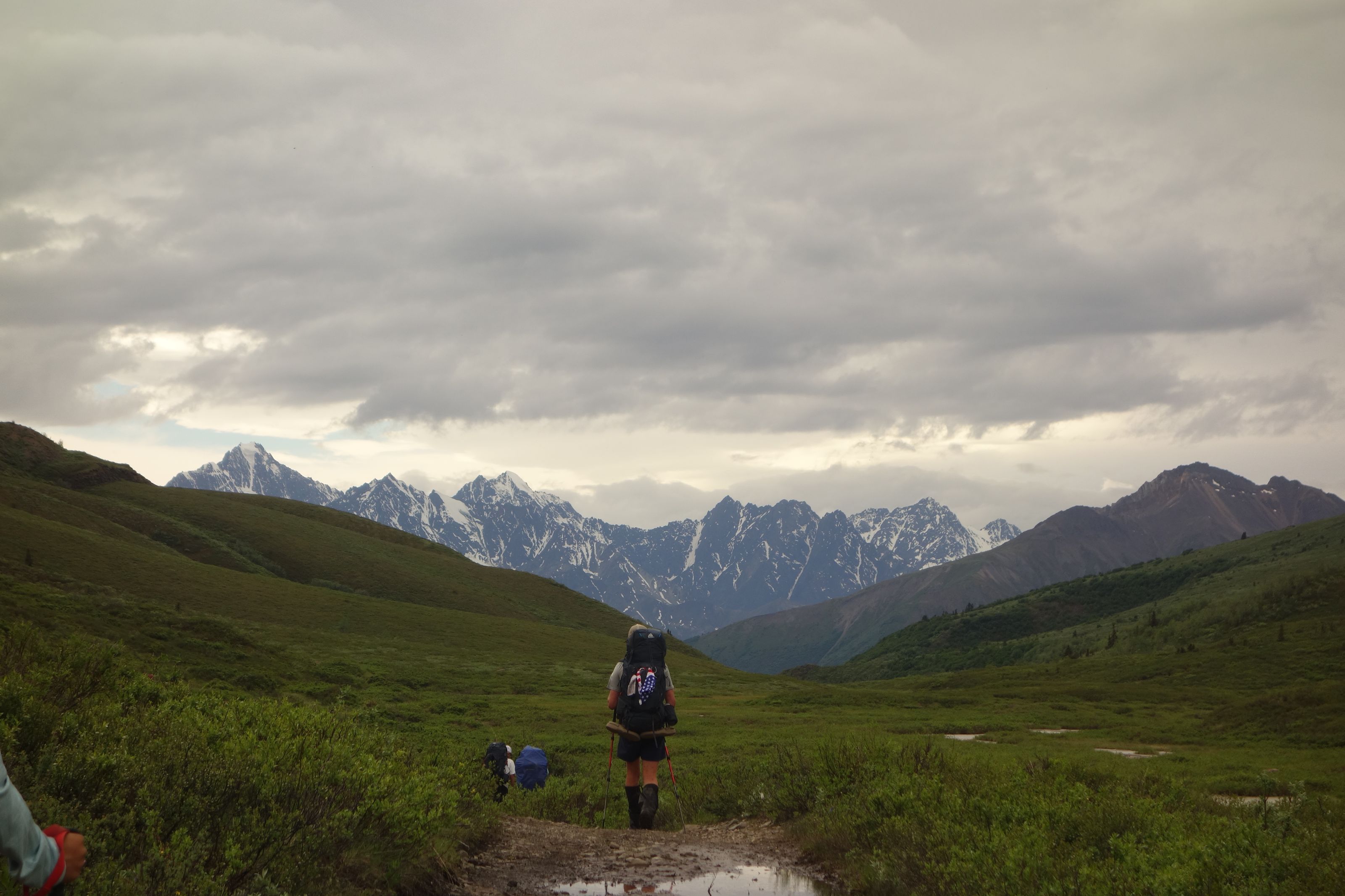 Hiker walking toward mountains
